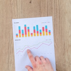 Man showing business graph on wood table